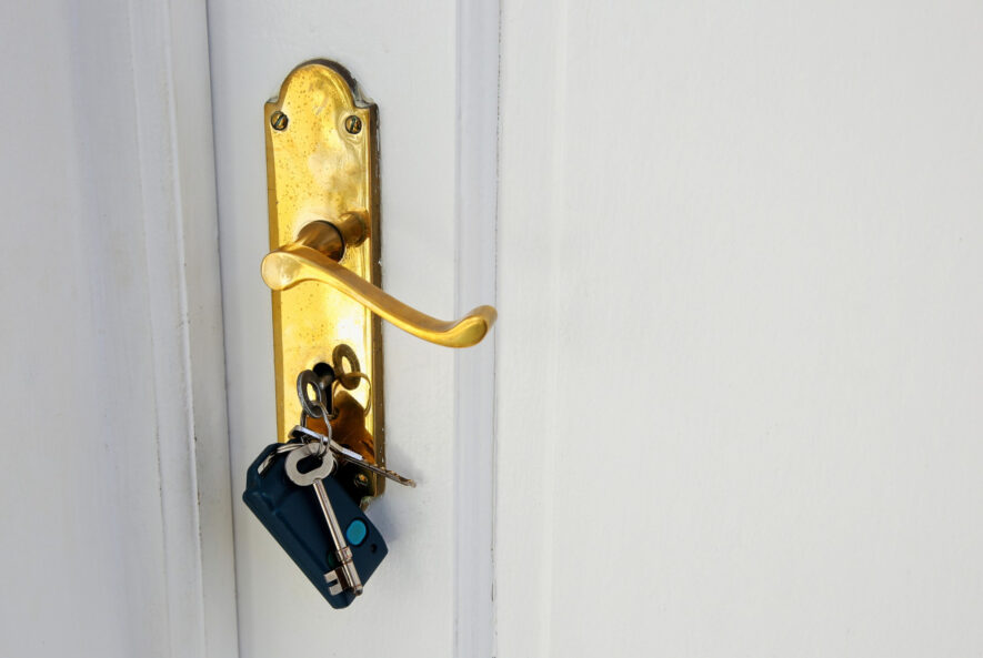 A locksmith assisting a customer with a car lockout using professional tools.