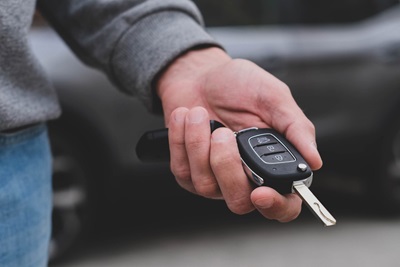 man-in-front-of-the-new-car-and-holding-keys-salesman-is-carrying-the-car-keys-delivere-e1696401738715