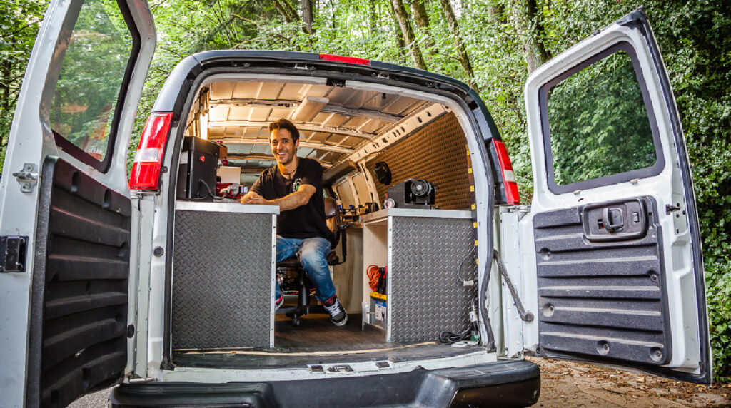 A locksmith assisting a customer with a car lockout using professional tools.