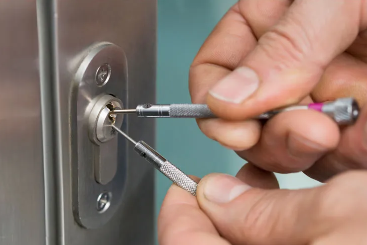 A locksmith using a key-cutting machine to create a duplicate key at AdenKeys.