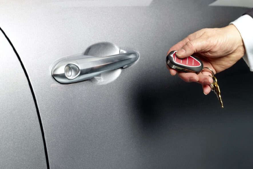 A locksmith using advanced technology to program a car key fob, enhancing vehicle security in Abu Dhabi.