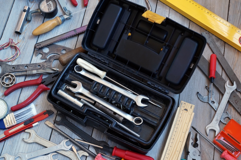 A locksmith using a key-cutting machine to create a duplicate key at AdenKeys.